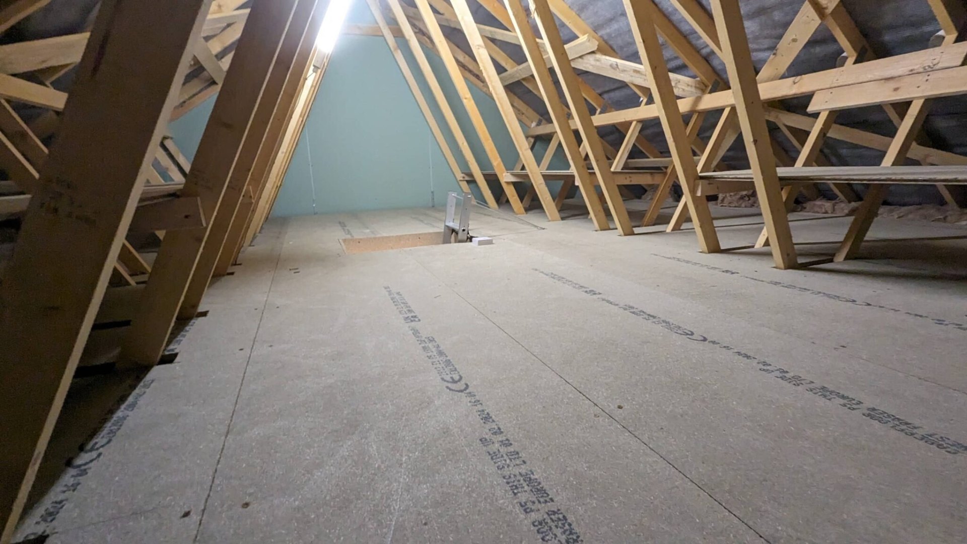 Boarded loft with strip lighting fitted overhead for safe working