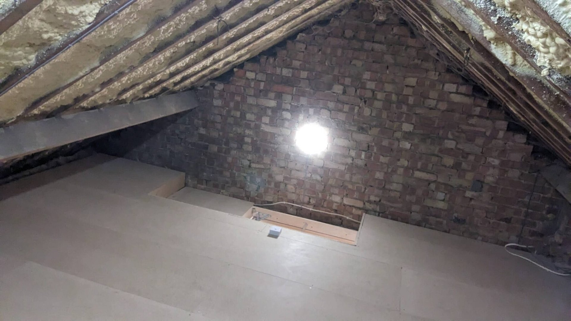 Boarded loft floor with central walkway through trusses