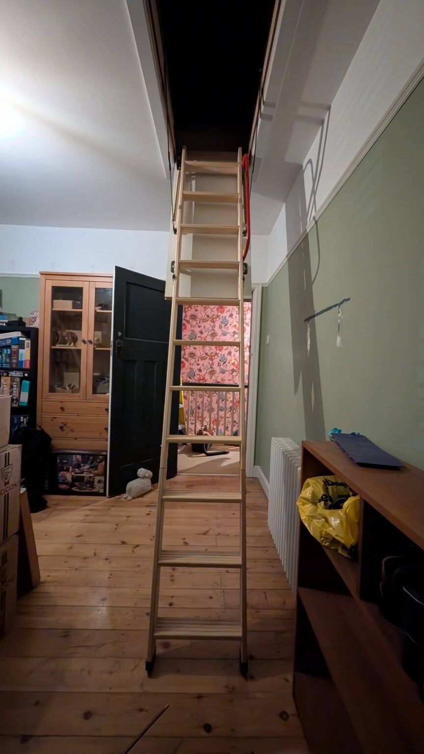 Wooden loft ladder fully extended into hallway, Solihull home