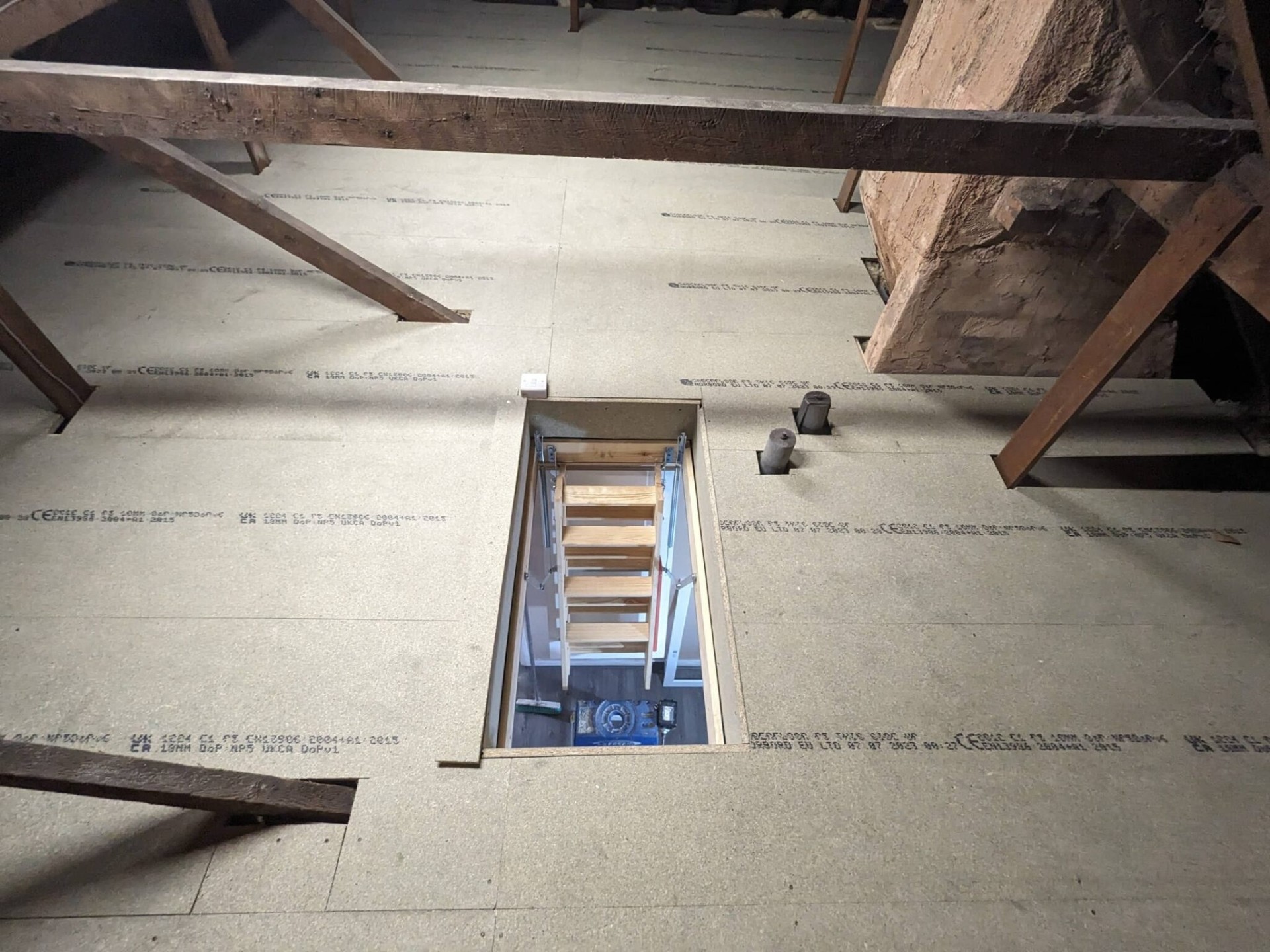 Wooden folding loft ladder lowered through new boarded hatch
