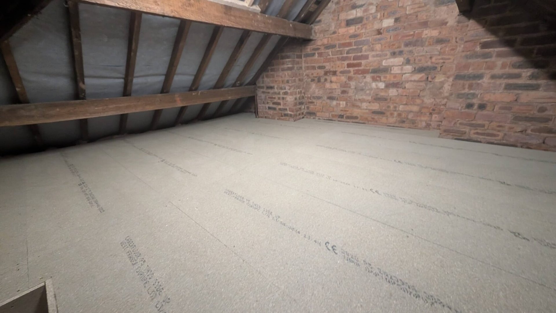 Clean finished loft boarding against original brick gable wall