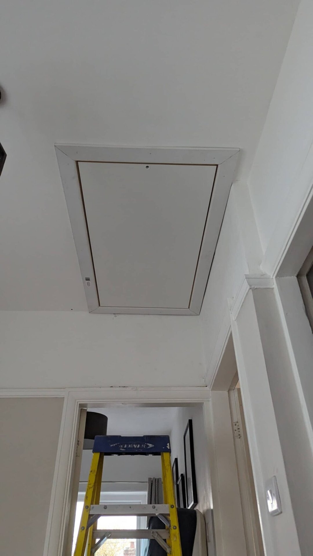 Insulated white loft hatch closed flush to landing ceiling