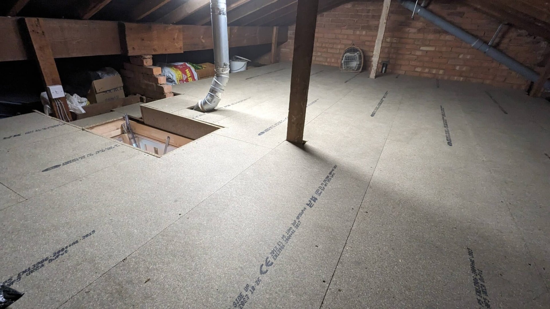 Boarded loft floor neatly cut around soil vent pipe
