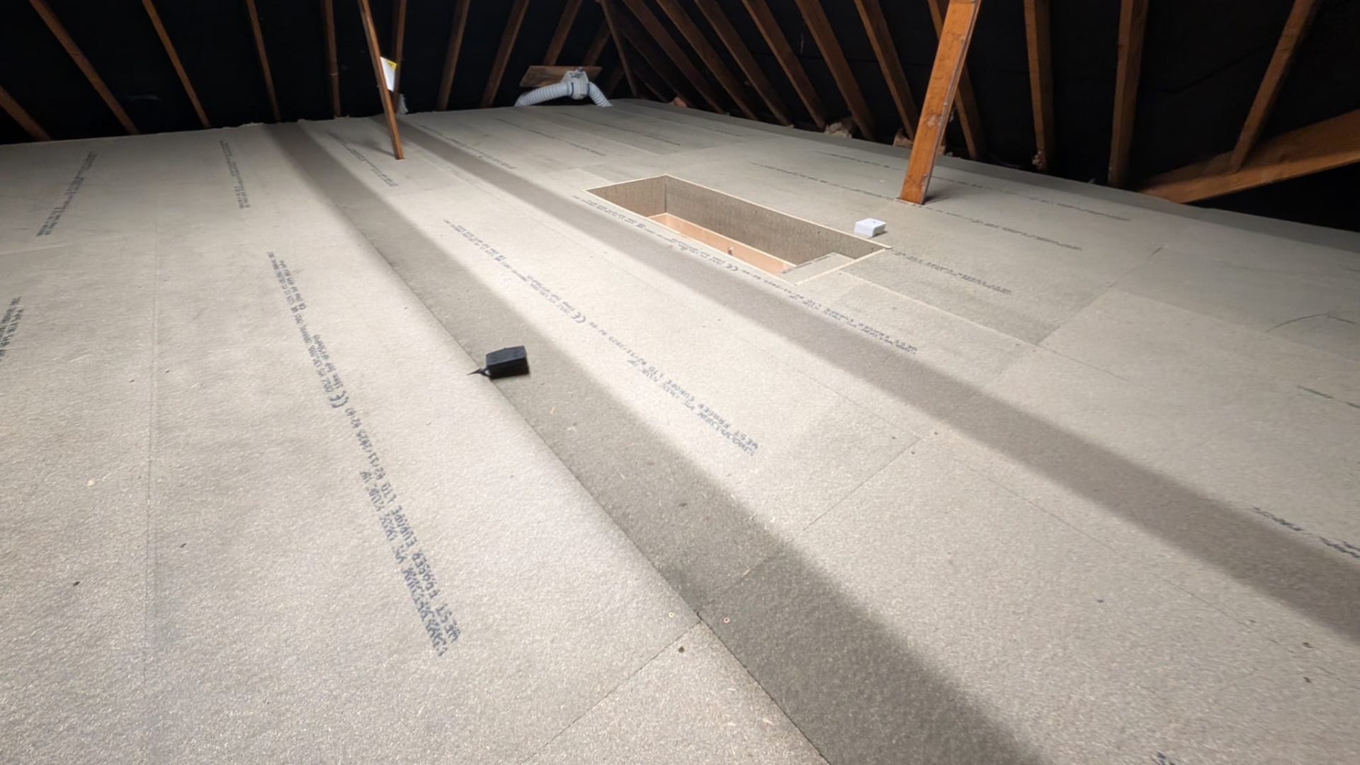 Boarded loft with clean cut around hatch and bracing timbers