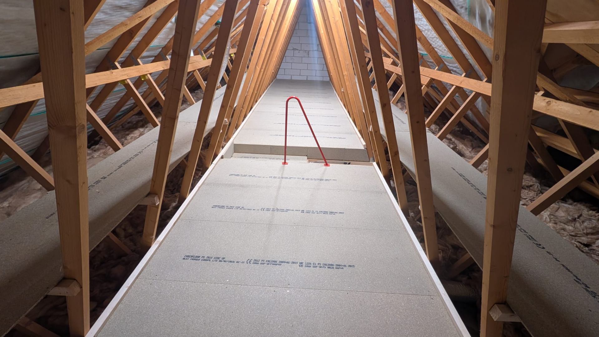 Long central walkway boarded through new-build trussed roof