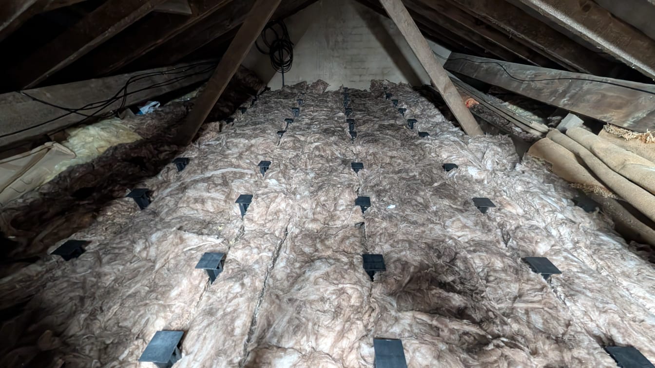 Wide loft boarding install with original gable wall visible