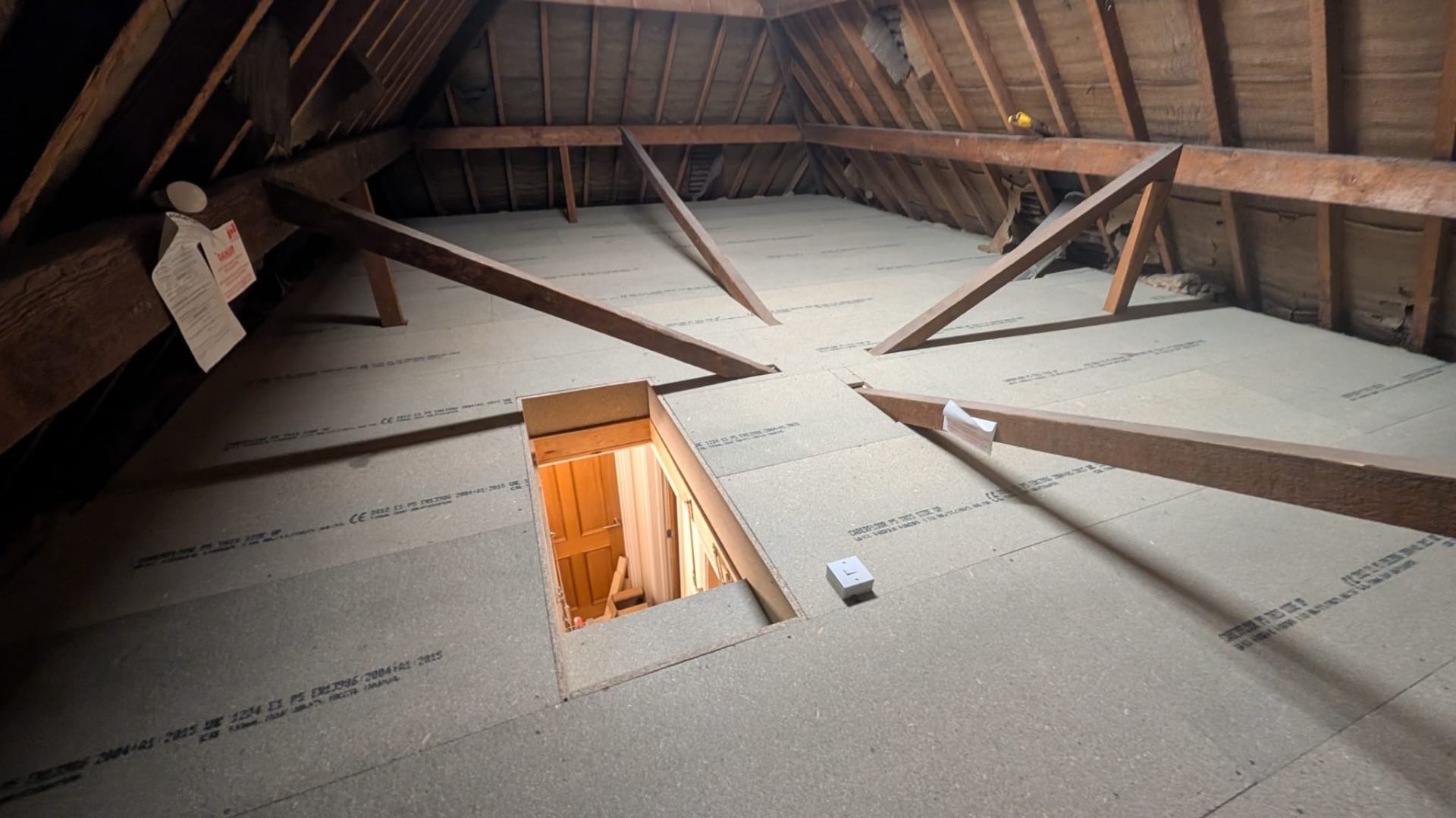 Boarded loft with new hatch opening cut neatly into ceiling